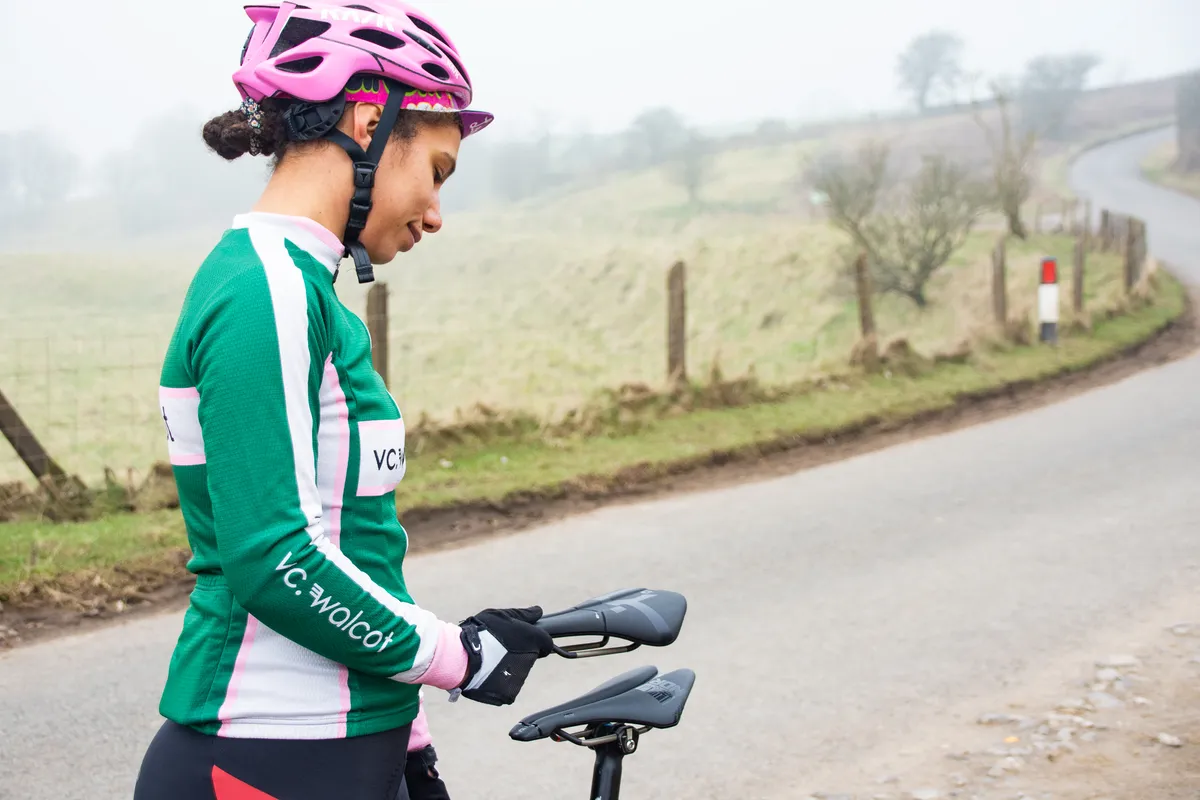 Female cyclist comparing two different saddles