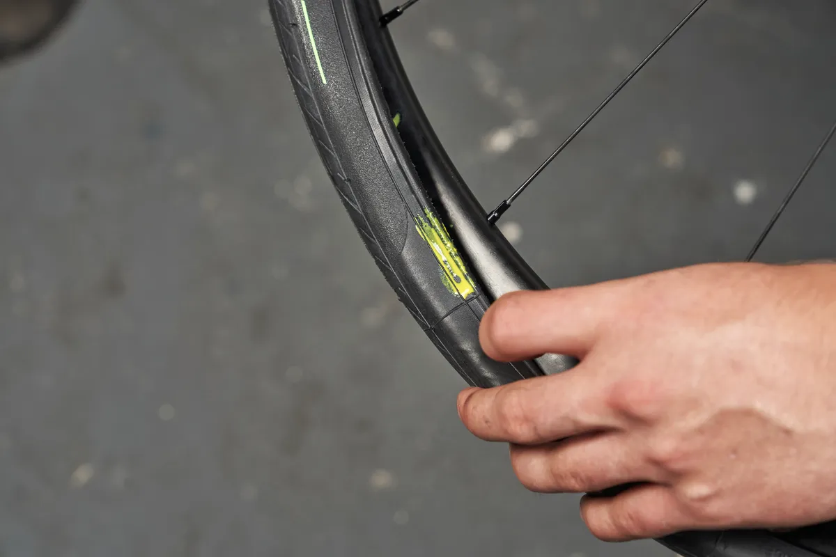 Putting a dab of sealant on the sidewall of a Pirelli Cinturato Velo tyre.