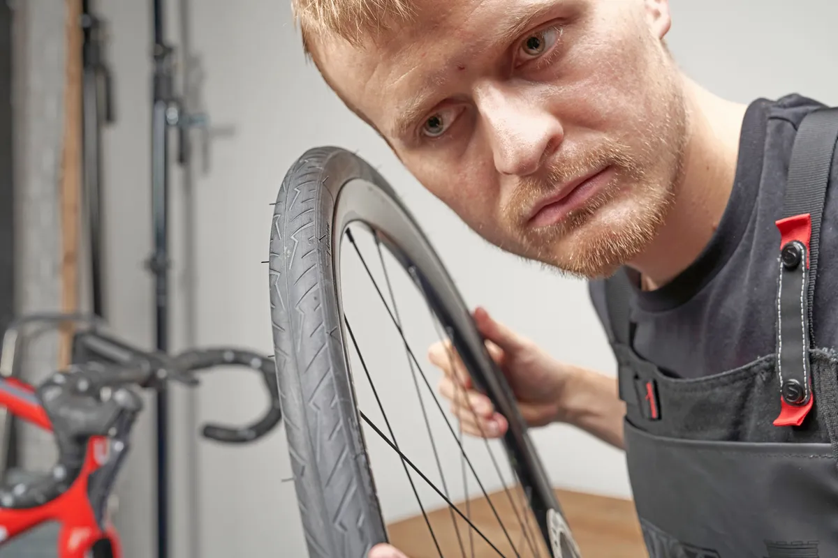 Mechanic listening for any noises in a tubeless tyre set-up
