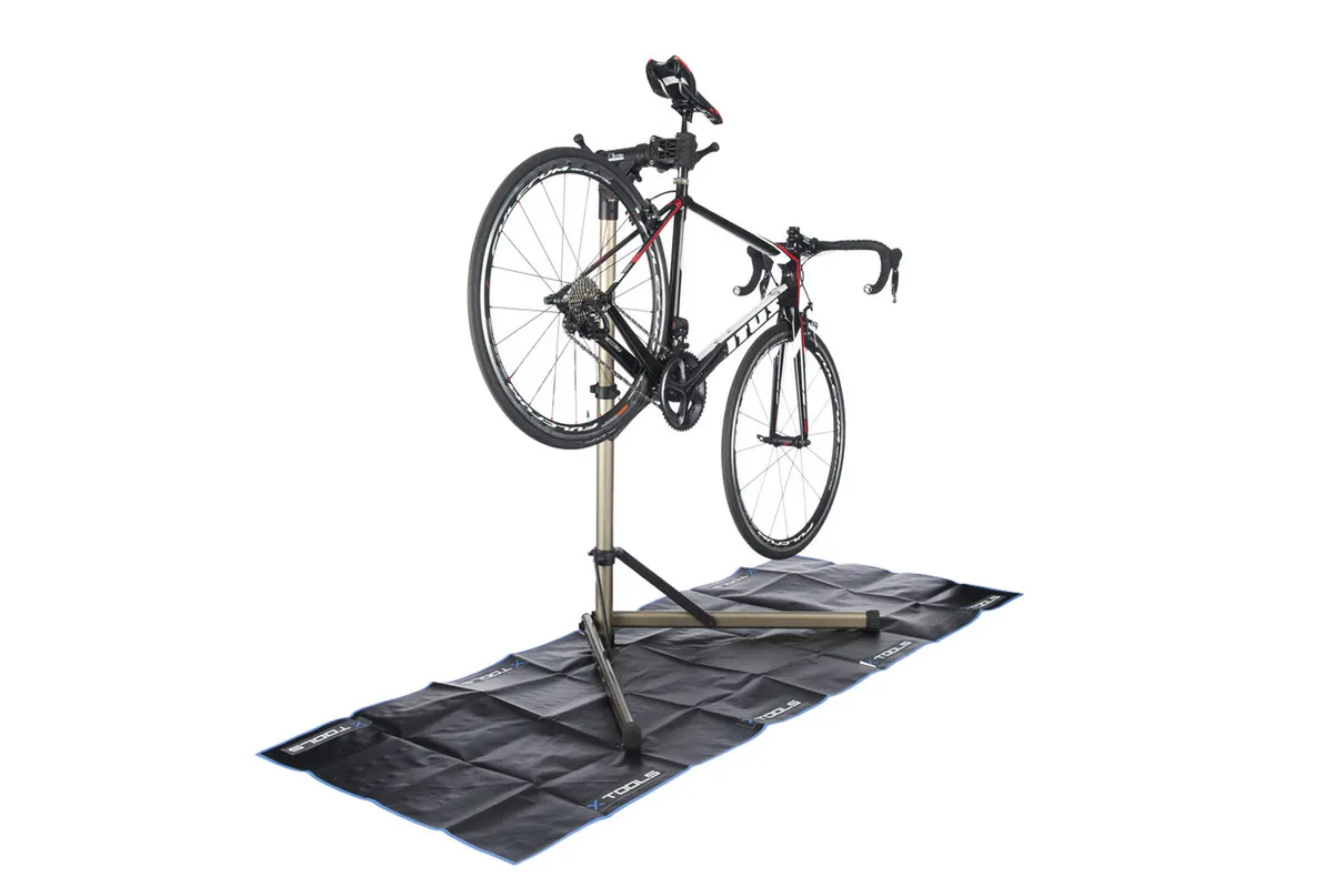 Photograph of a bike held up in a bike stand on a black matt