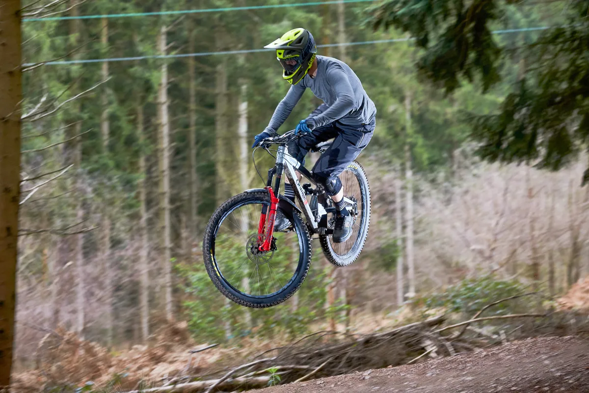 Alex Evans riding an Orange Stage 6 over a jump at Cannop, Forest of Dean, Gloucestershire. March 2019