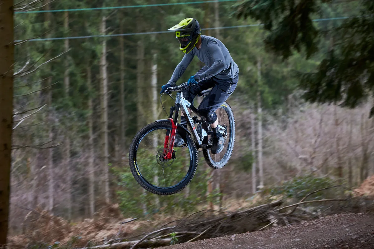 Alex Evans riding an Orange Stage 6 over a jump at Cannop, Forest of Dean, Gloucestershire. March 2019.