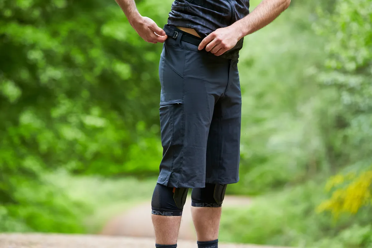 Man tightens belt clasp on Mission Workshop The Traverse shorts