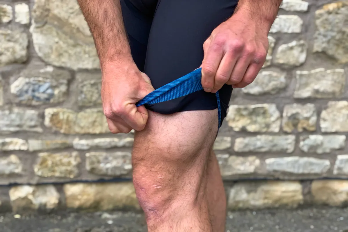 Man wears 7Mesh MK3 padded cycling short, revealing silicone gripper at the base of the shorts' hem