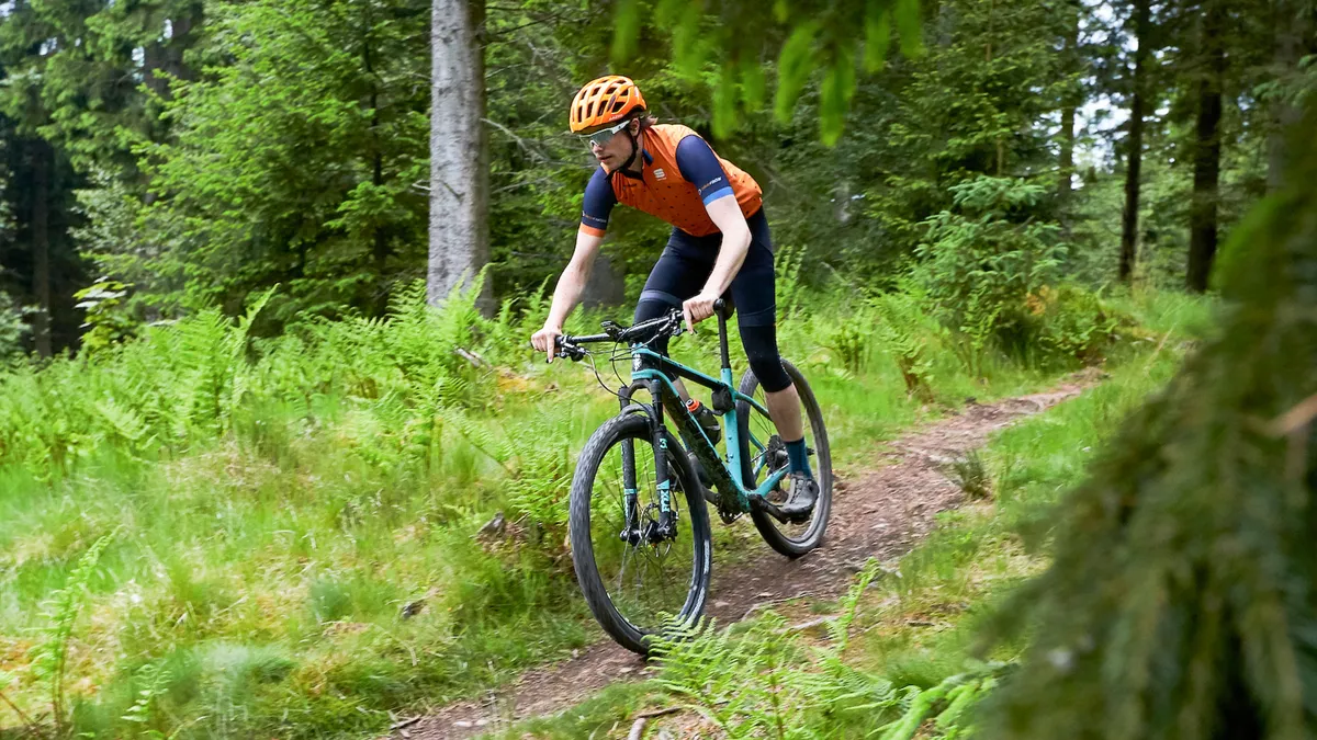 male cyclist riding through woodland woods