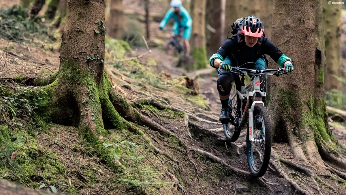 female cyclist riding mountain bike in woods