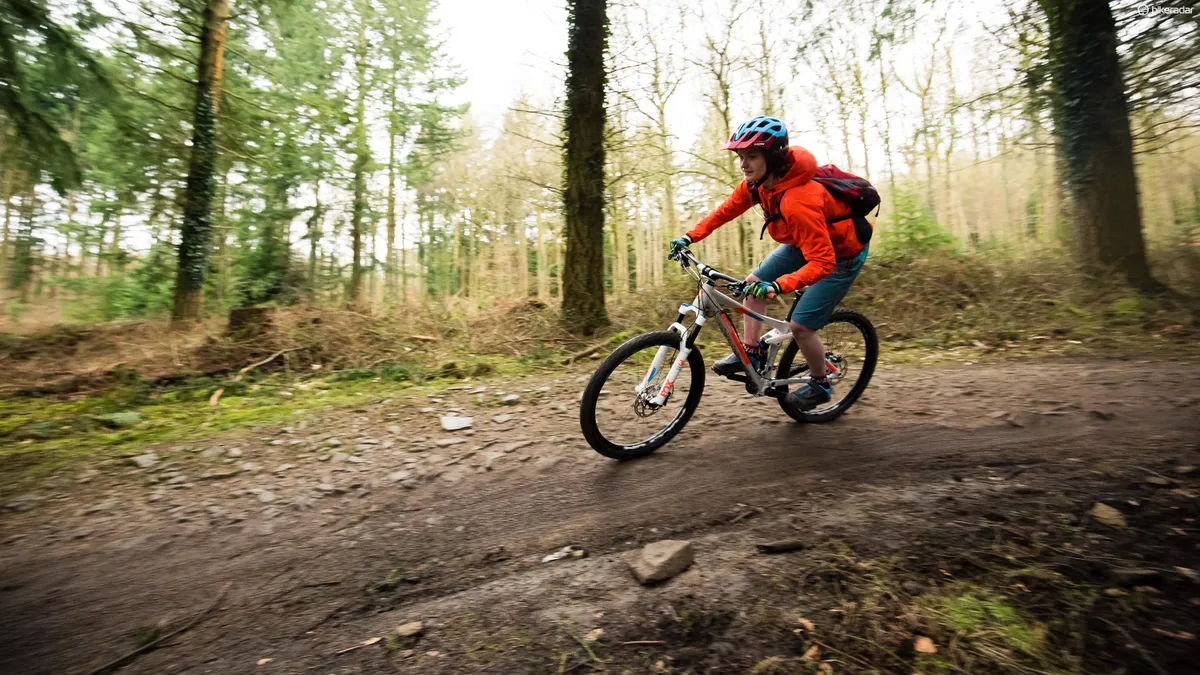female cyclist riding mountain bike in woods
