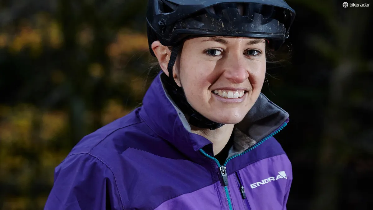 female cyclist wearing purple mountain bike jacket