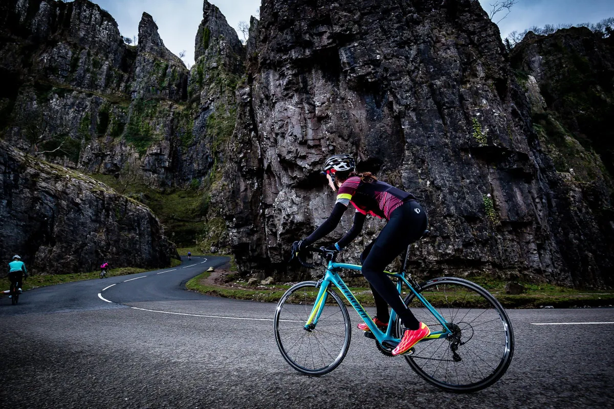 Female cyclist riding blue road bike Cheddar Gorge