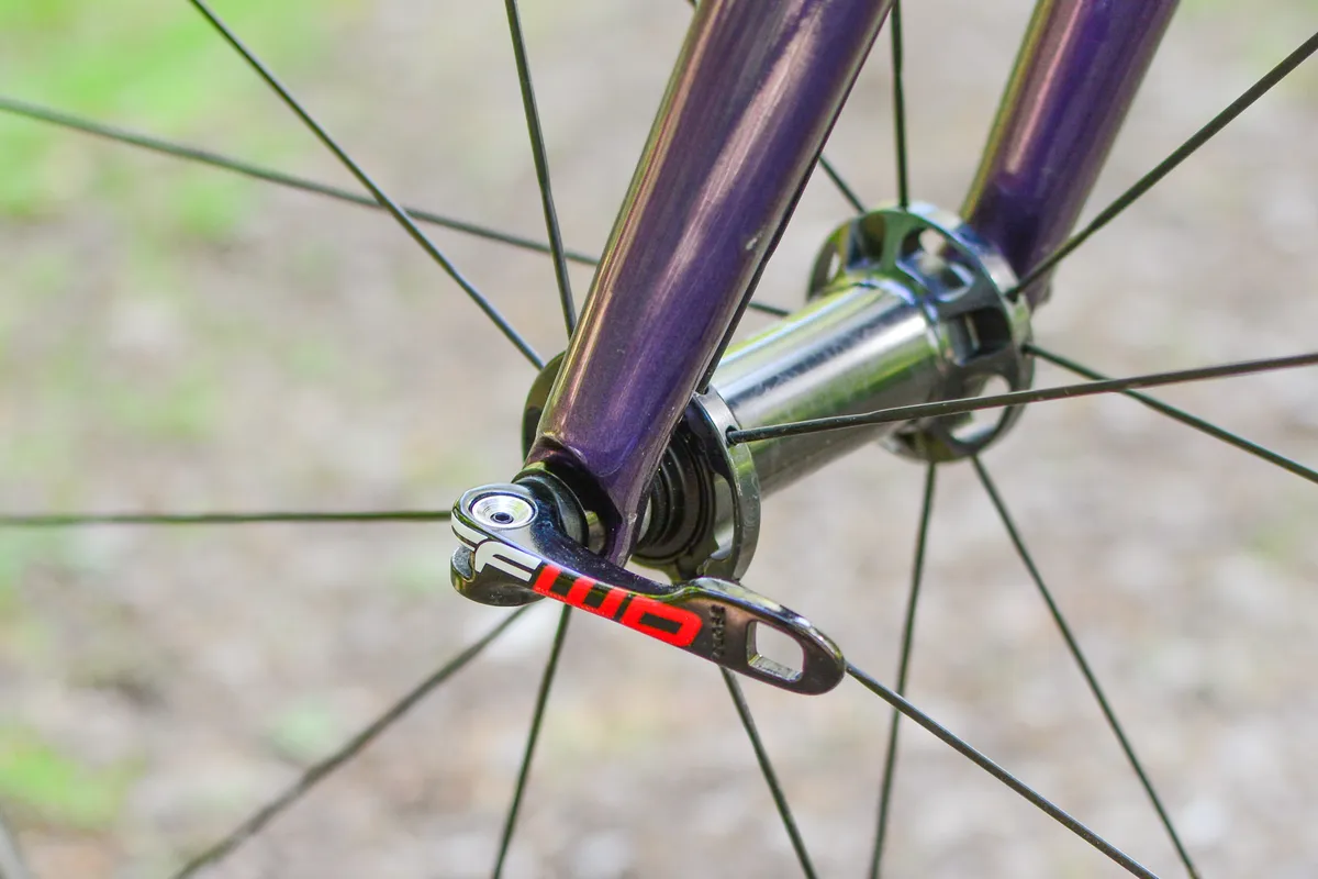 Close up of road bike front wheel showing quick-release skewer