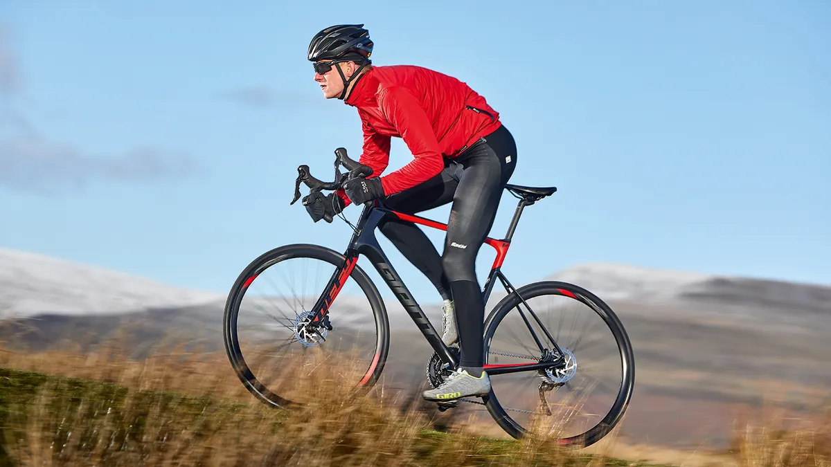 Male cyclist riding red and black bike in countryside