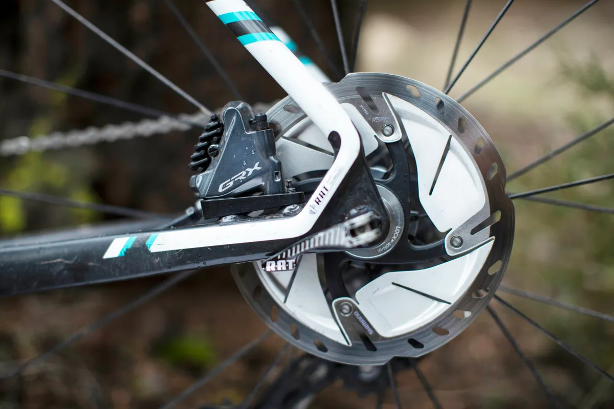 Shimano GRX disc brake caliper and disc mounted to rear of bike frame