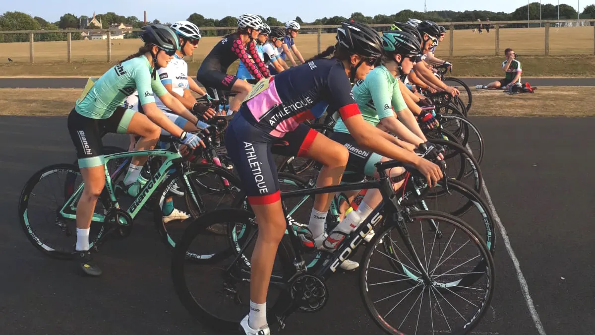A group of women on bikes lined up to start a road cycling race