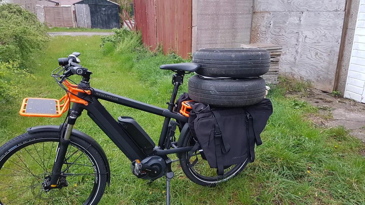 Cargo bike carrying car wheels