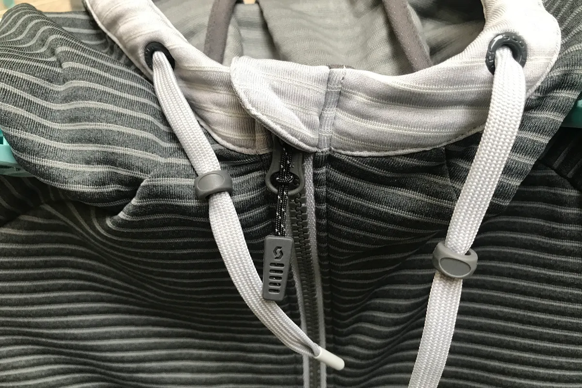 Photo of the neckline of a zip up top in dark and light grey by Scott