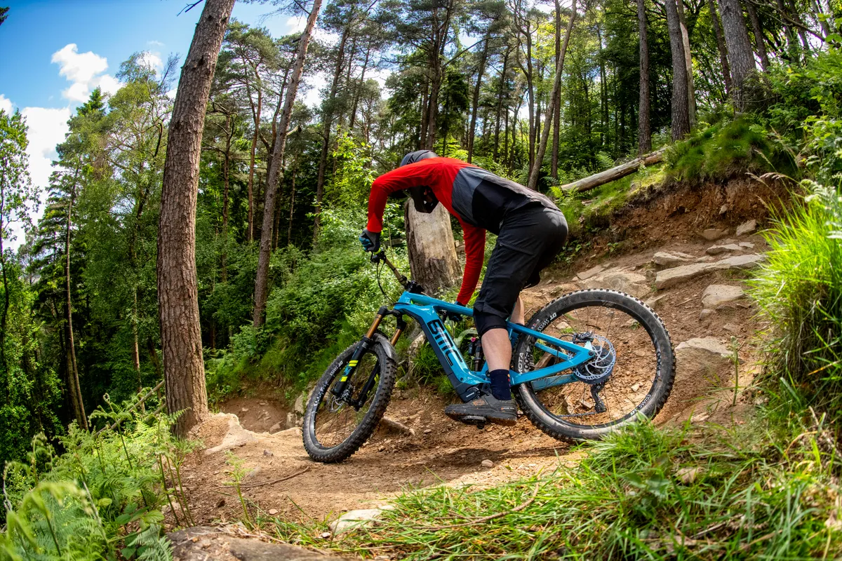 Man rides and an electric mountain bike off road at Cwmcarn in South Wales