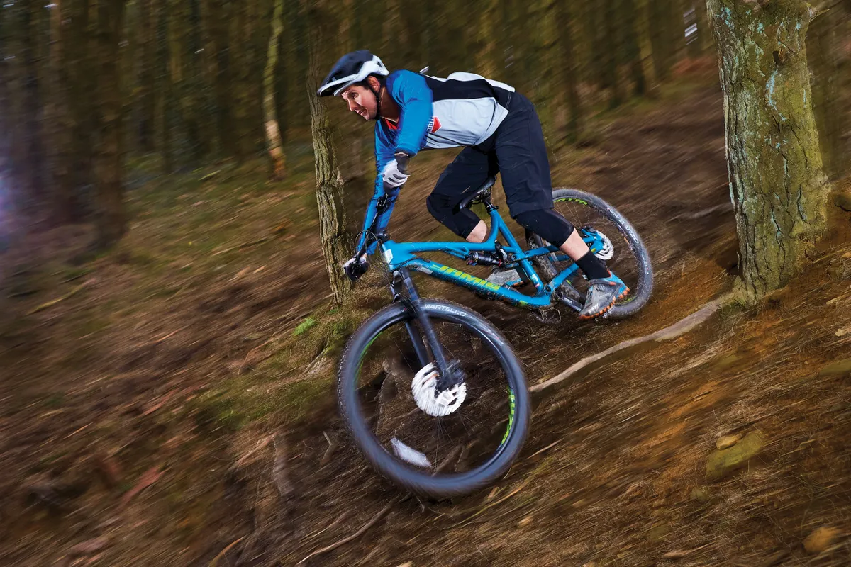 Male cyclist riding blue full suspension mountain bike
