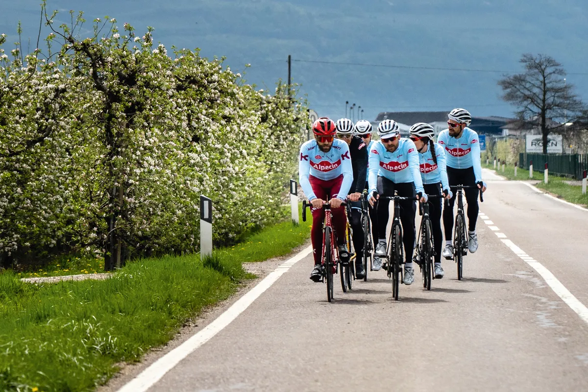Group of road cyclists riding down hill