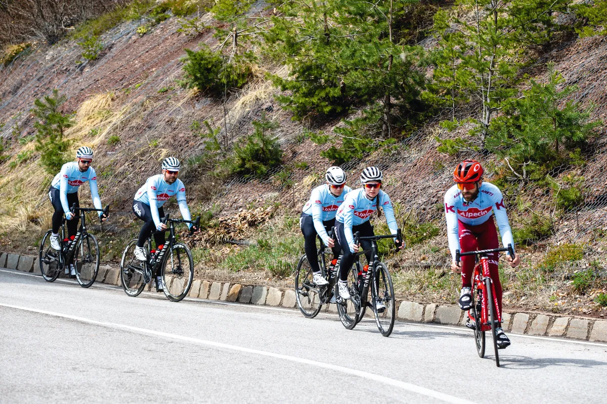 Group of road cyclists riding down hill