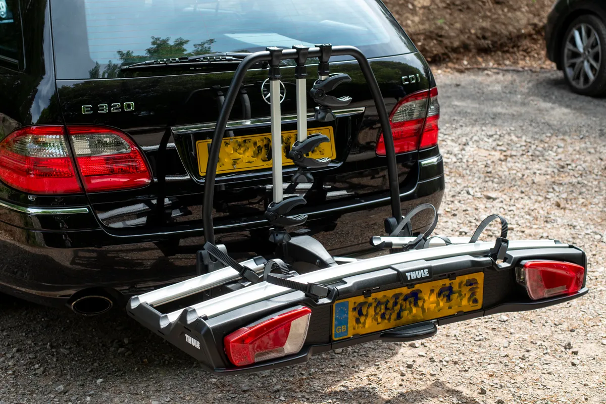 Thule VeloSpace XT3 towbar mounted bike rack attached to a black Mercedes estate car with no bikes on it