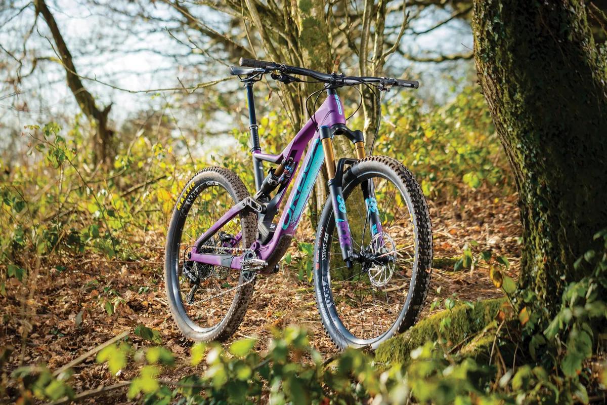 Purple full-suspension mountain bike in woods