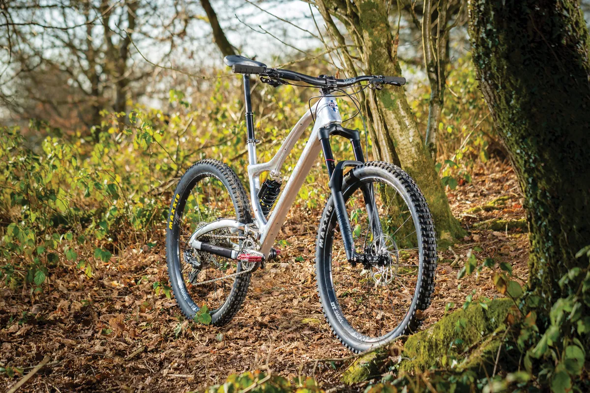 Silver full-suspension mountain bike in woods