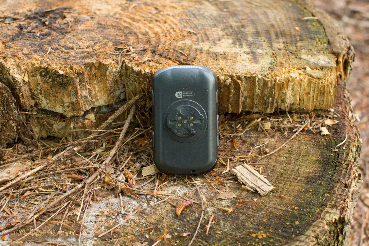 Underside of GPS bike computer Garmin Edge 530, sitting on a log