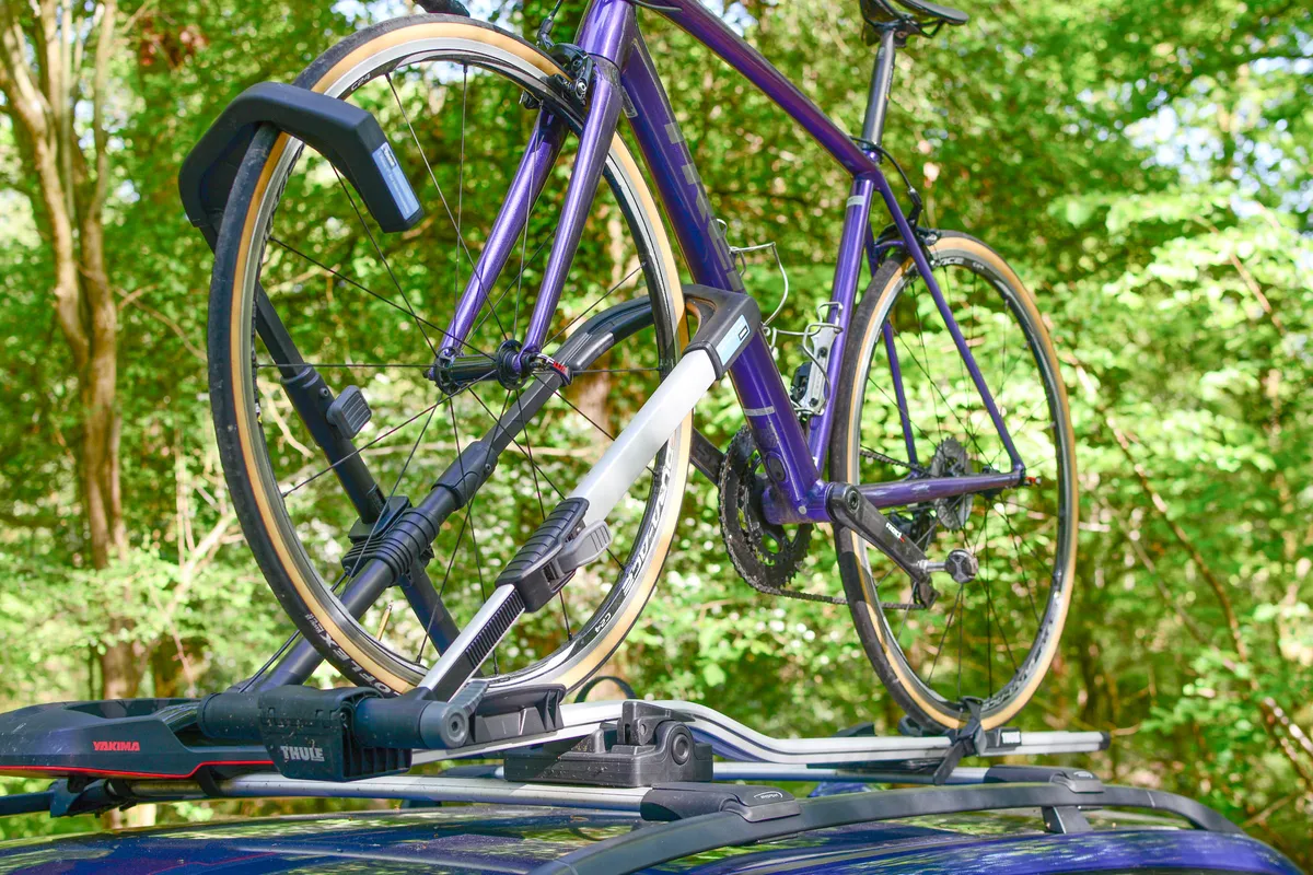Purple bike on roof-mounted bike rack, on car