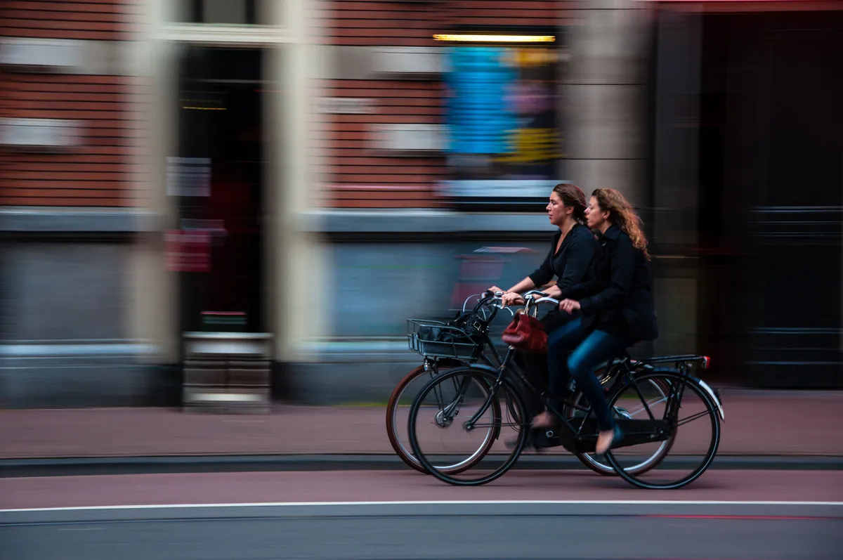 Two cyclists rding through street