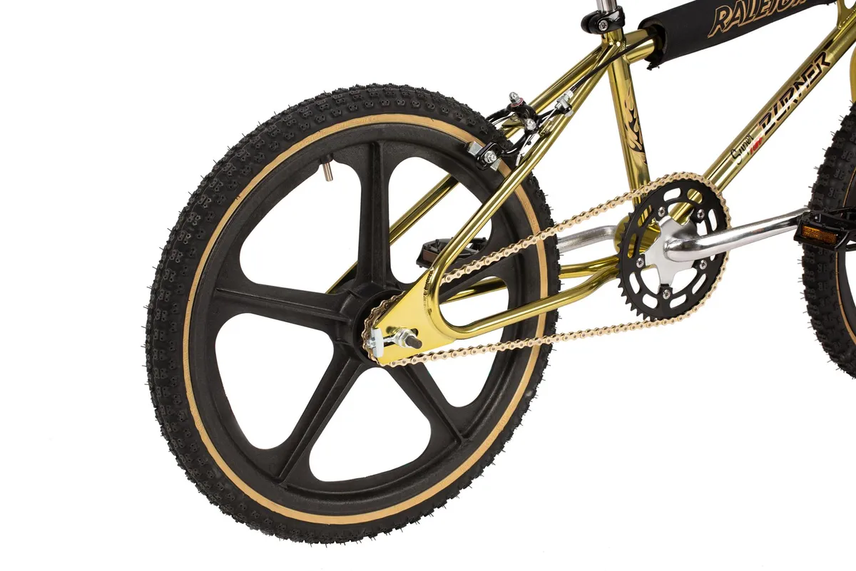 Five spoke wheel on gold BMC bike.