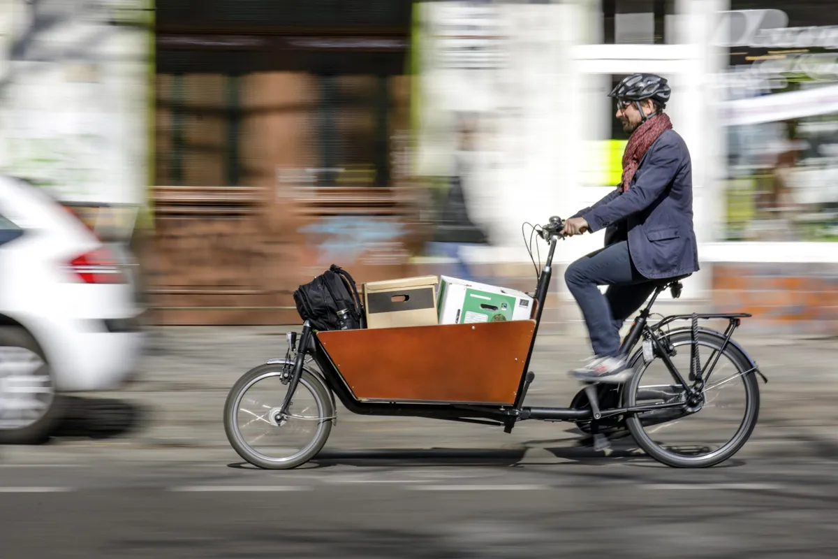 Man riding bakfiets cargo bike filled with boxes