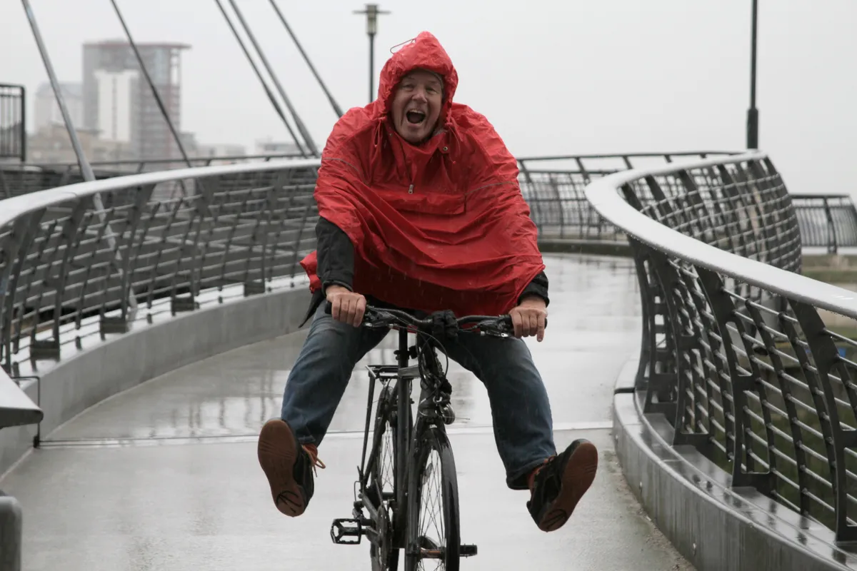 Man in rain on bike having fun