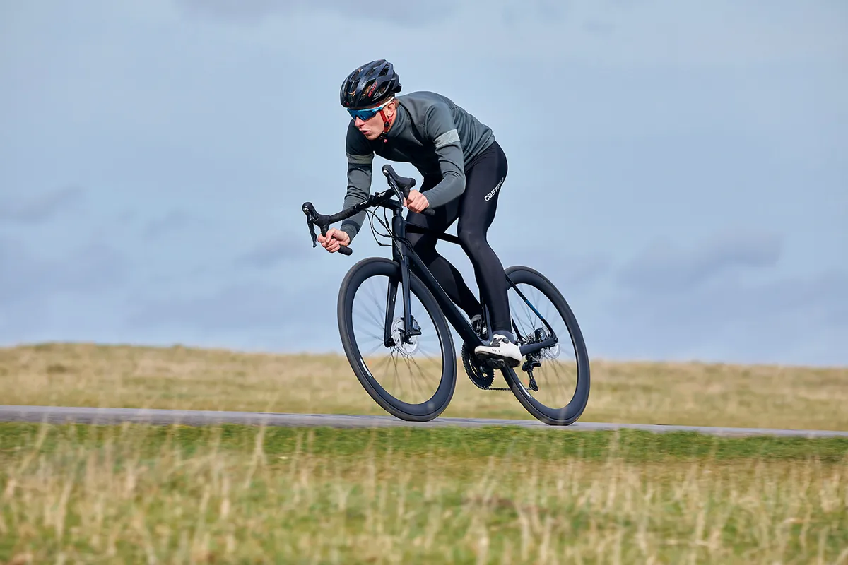 Cyclist in grey top riding a black Vitus ZX-1 CRS Aero Disc road bike in countryside