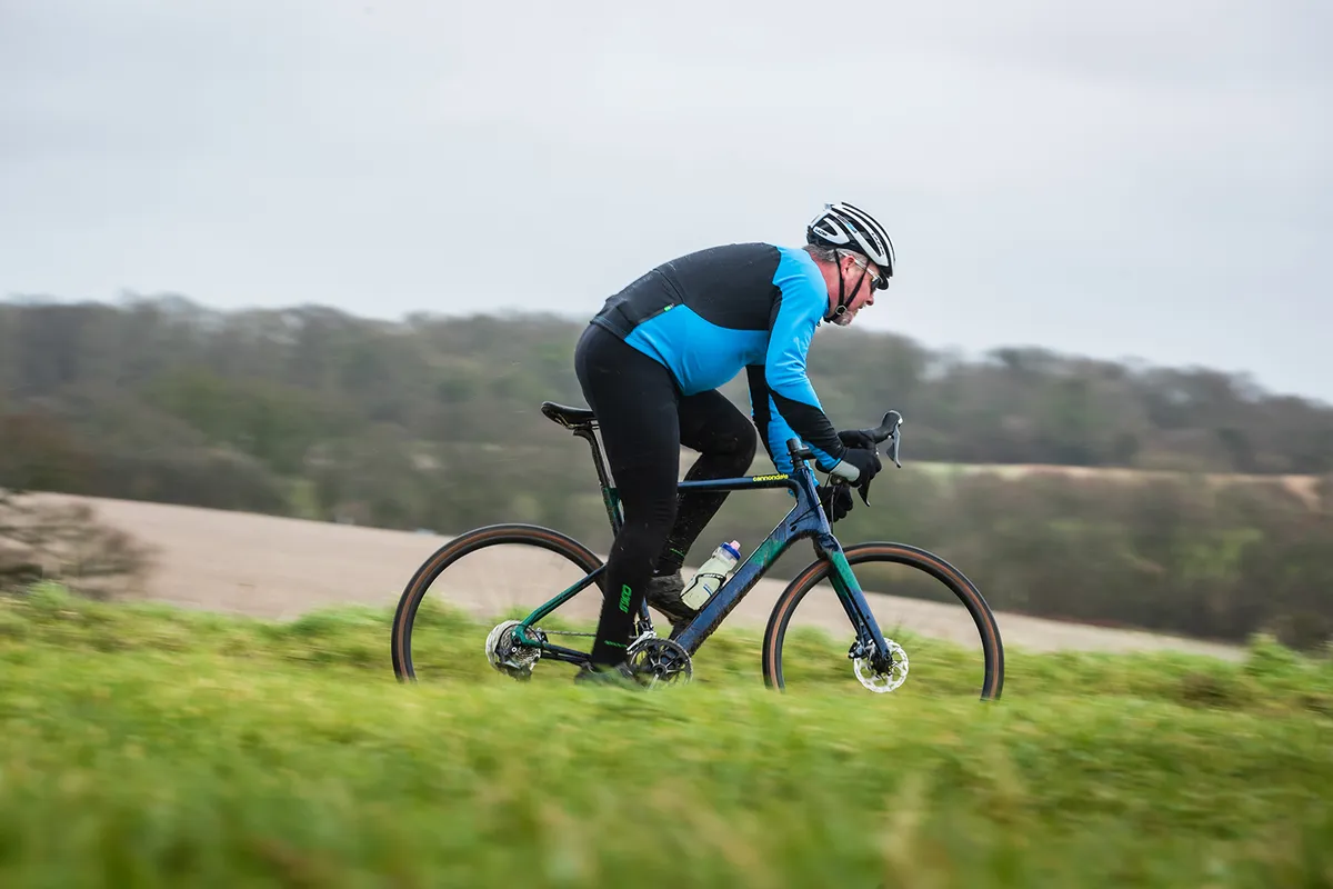 Male cyclist in blue riding a blue Cannondale Topstone Carbon gravel bike