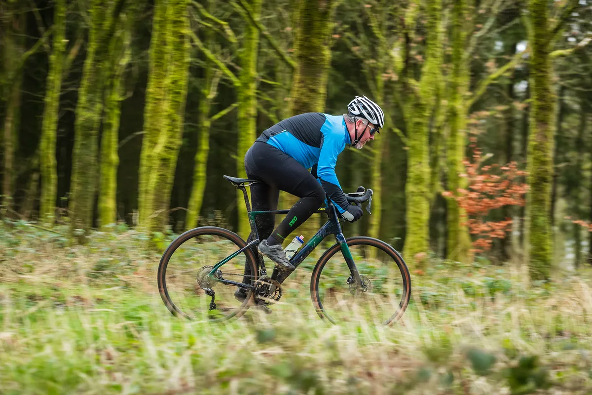 Male cyclist in blue riding a blue Cannondale Topstone Carbon gravel bike