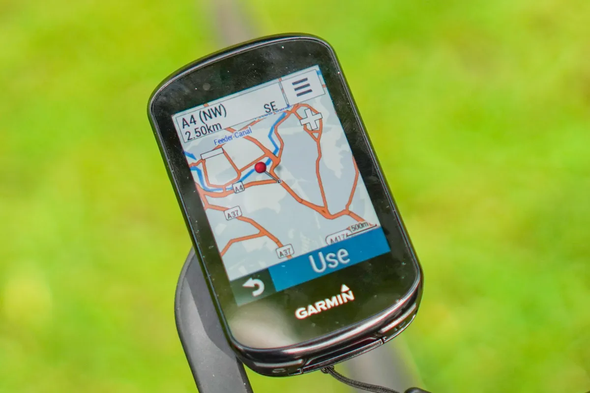 Garmin Edge 830 GPS bike computer with on-device mapping connected to an iPhone with Garmin Connect app showing a selected route