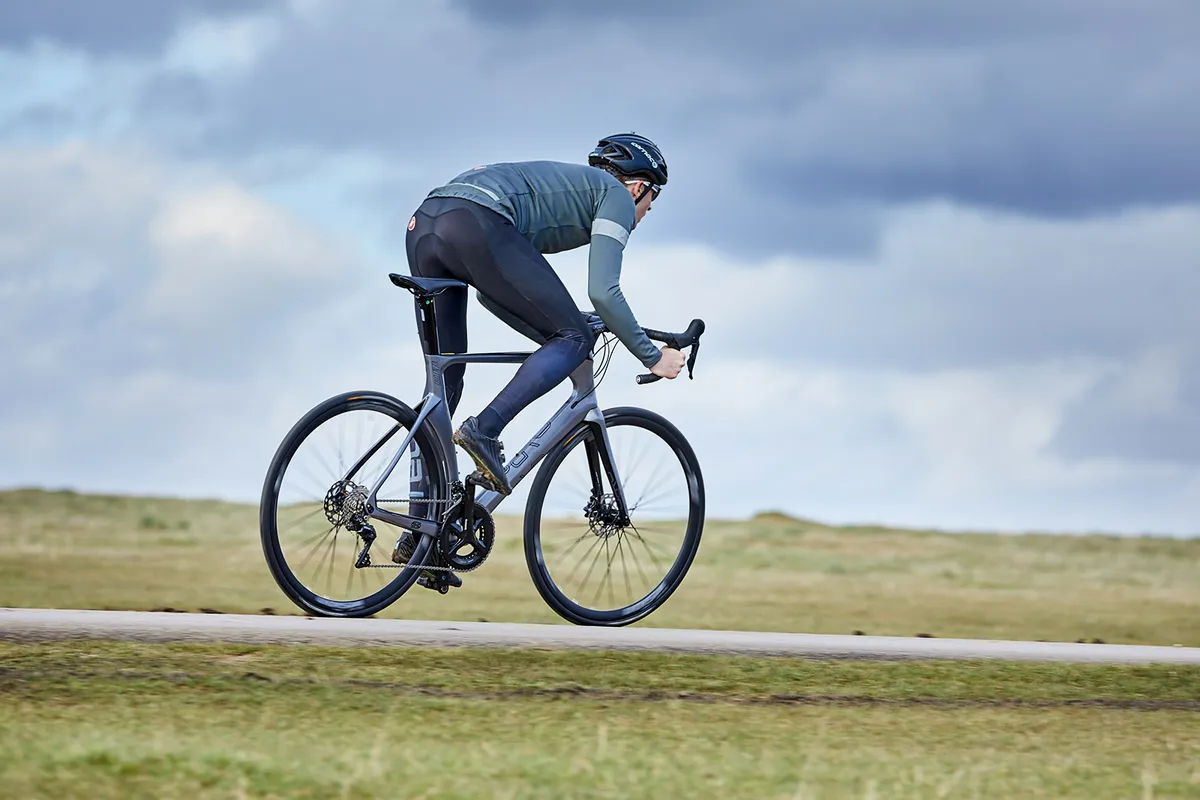 Cyclist in grey top riding a gloss grey Orro Venturi Evo road bike