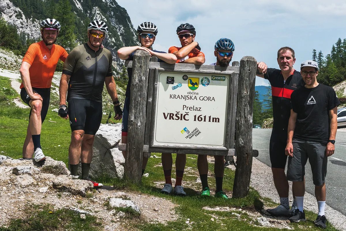 Cyclist find time for a photo shot at the summit of the Vřsič Pass in the Julian Alps of Slovenia