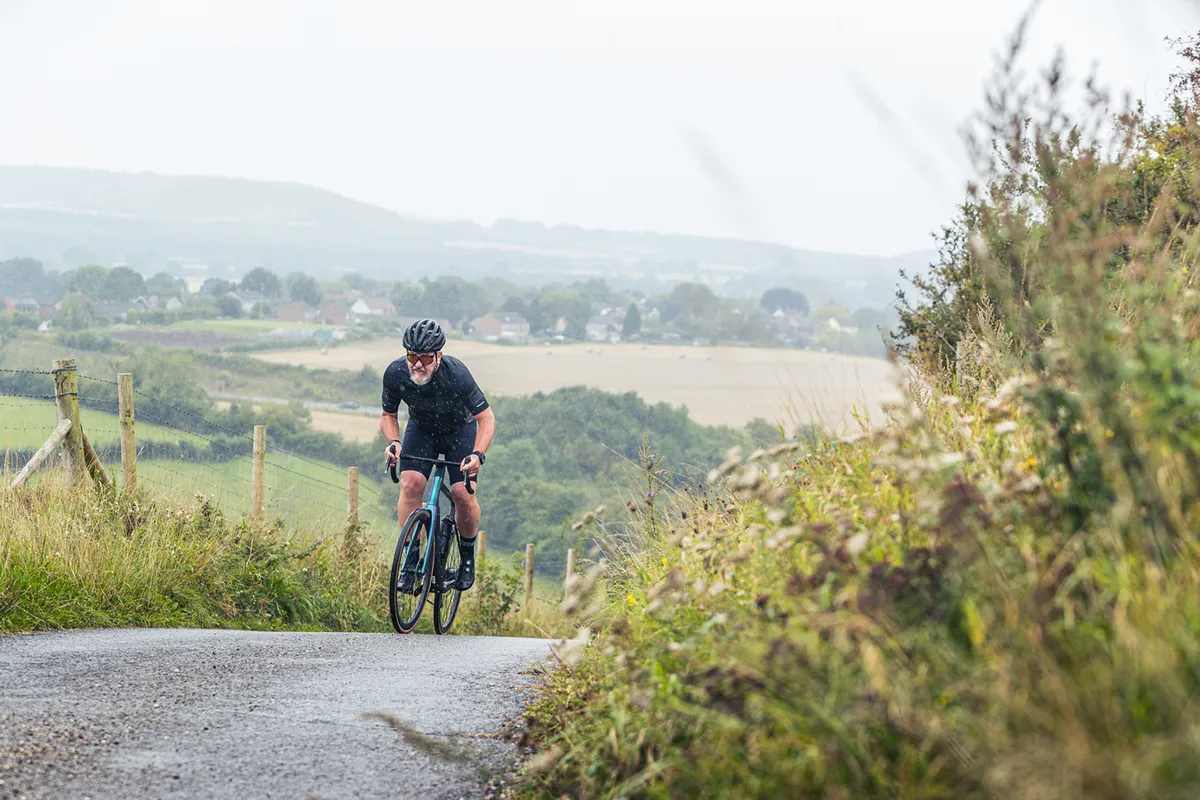 Male cyclist riding a green Scott Addict eRIDE Premium through the countryside