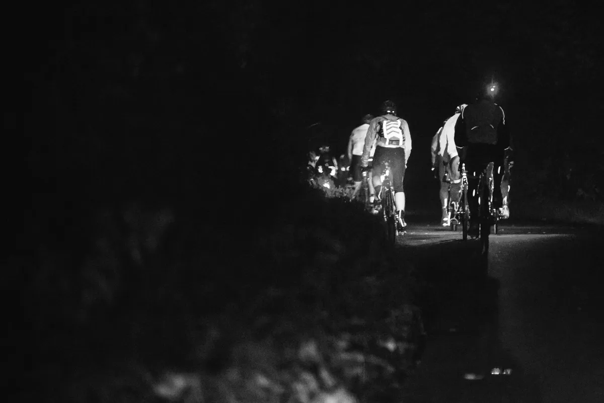 Group of road cyclists riding at night