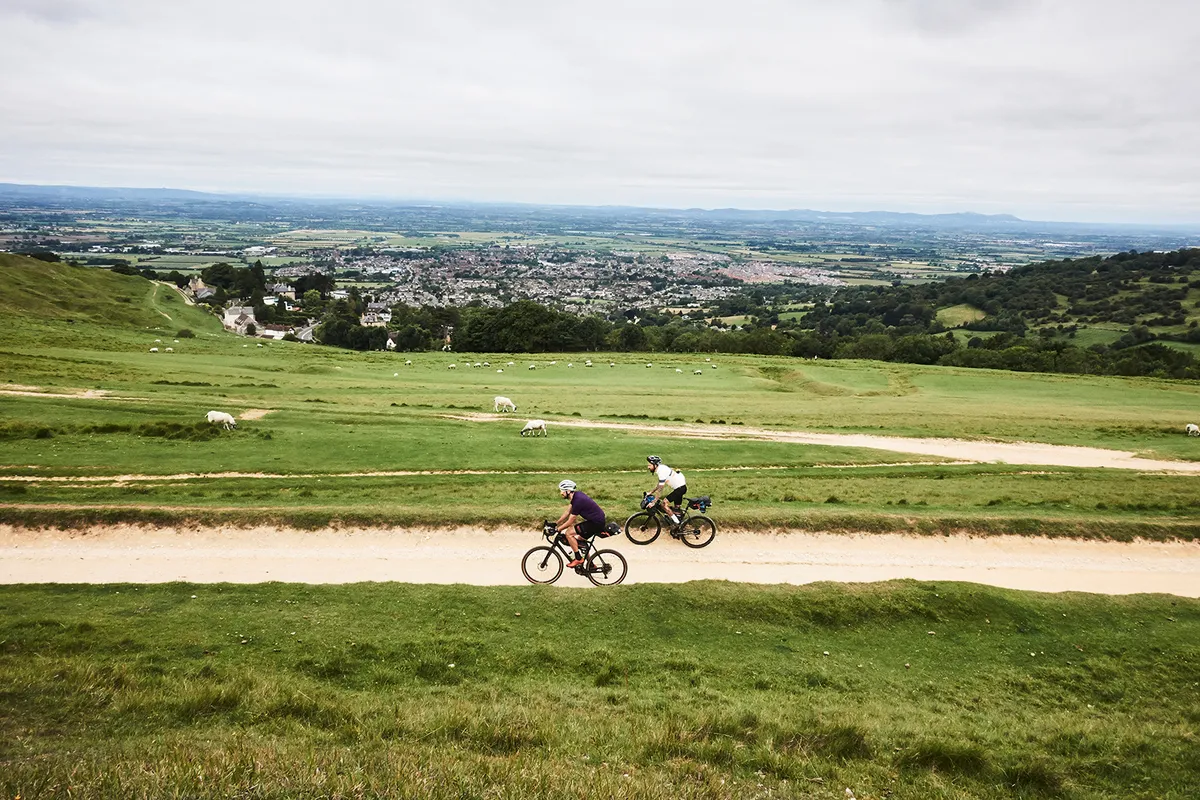 Two male cyclists riding through the countryside on touring bikes