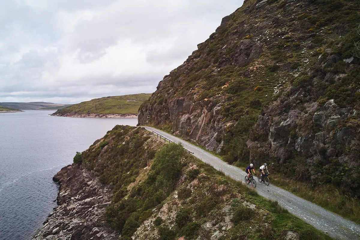 Two male cyclists riding gravel bikes through Wales while on one of the Komoot routes