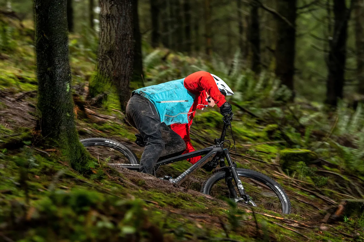 Cyclist in red and blue top riding the Forbidden Dreadnought XT full suspension mountain bike