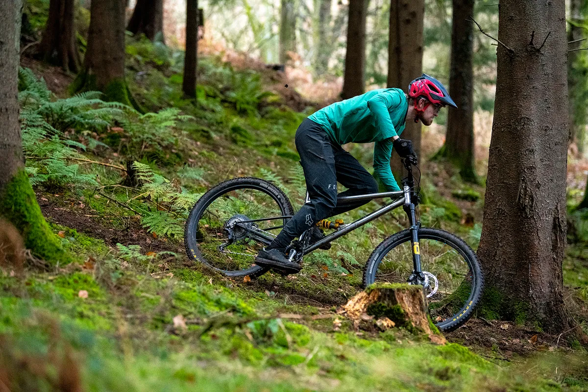 Cyclist in green top riding the Starling Murmur full suspension mountain bike