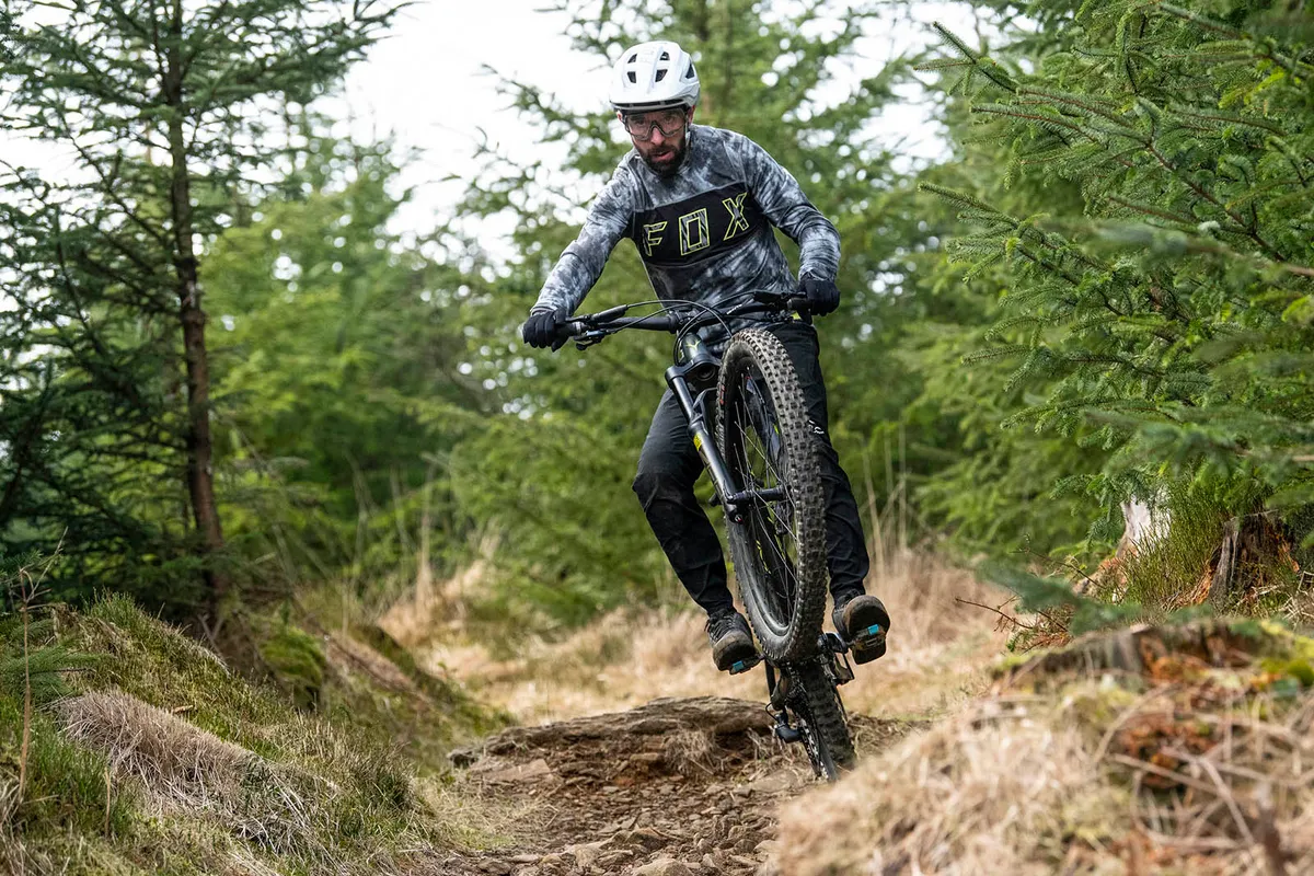 Male cyclist in grey top riding the Whyte G-180 RS 29 V1 full suspension mountain bike