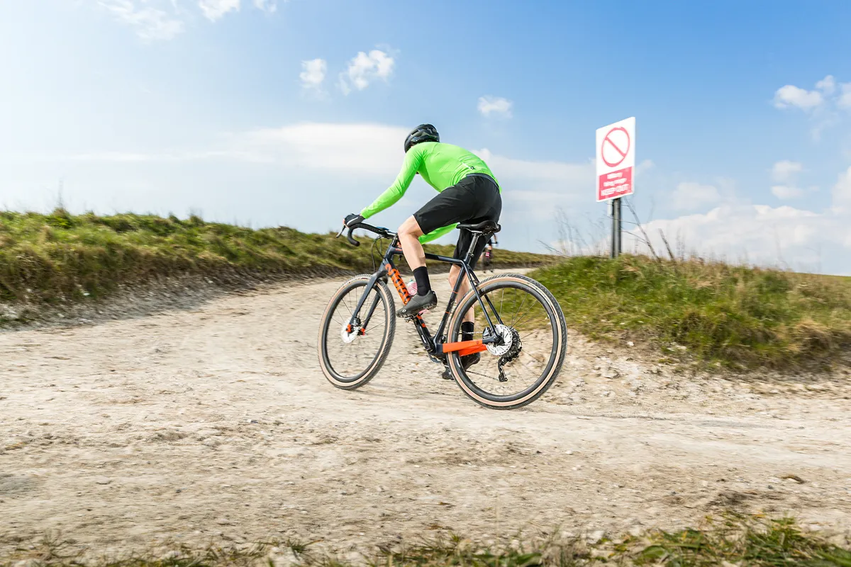 Cyclist in green top riding the Pearson Off Grid gravel bike