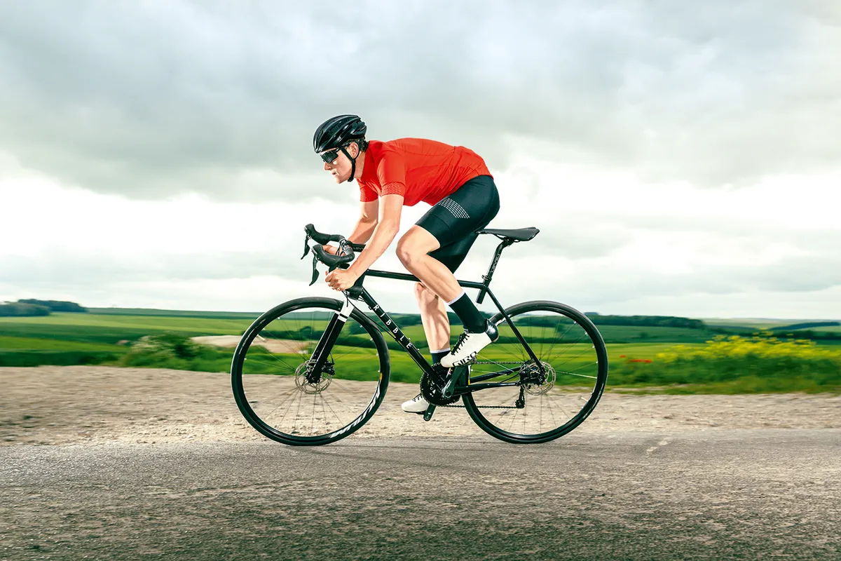 Male cyclist in red riding the Ribble Endurance 725 Disc - Base road bike