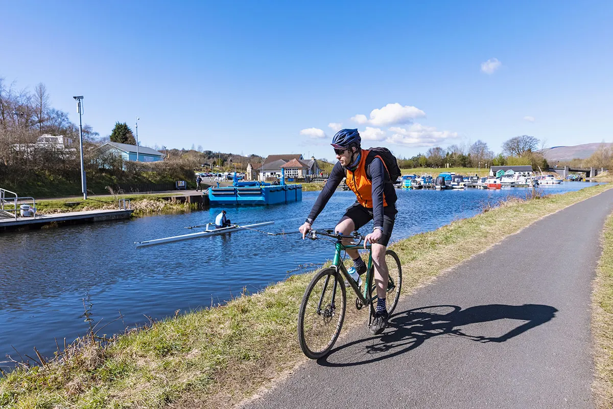 A man cycling along a canal, John Muir Way