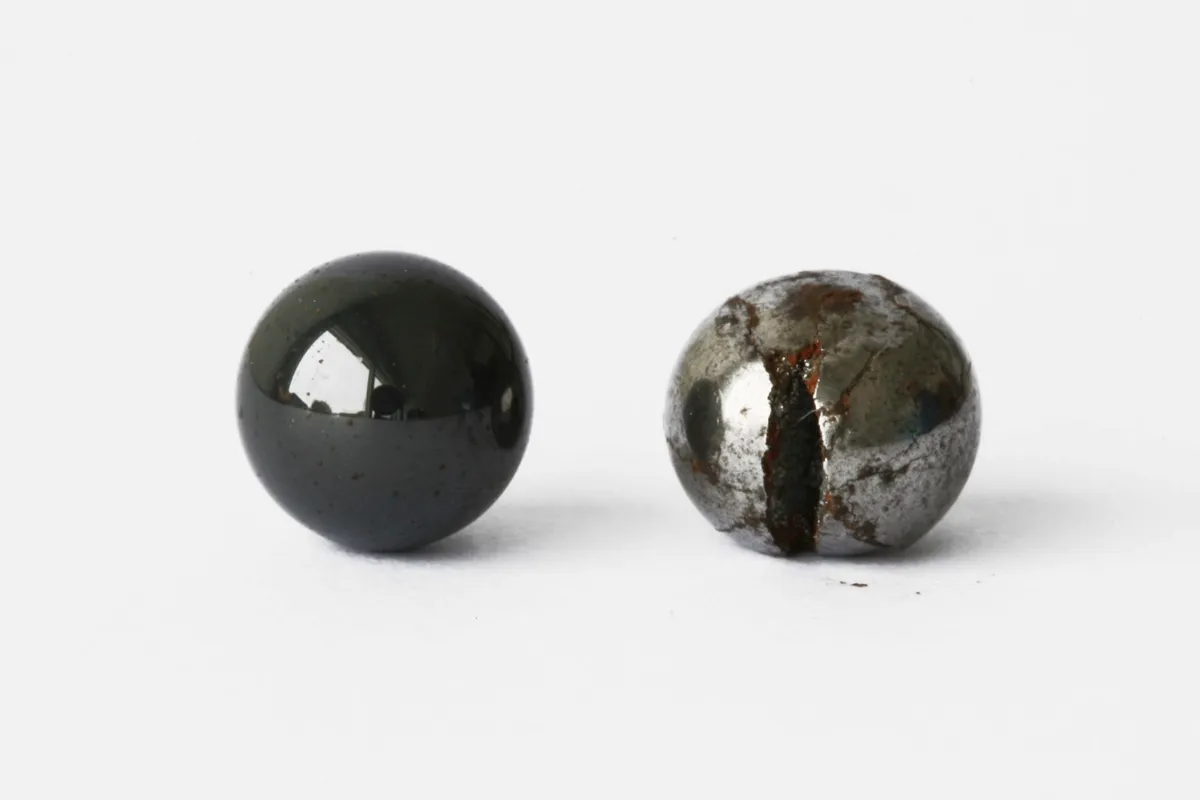 Image of a ceramic bearing and a cracked steel bearing