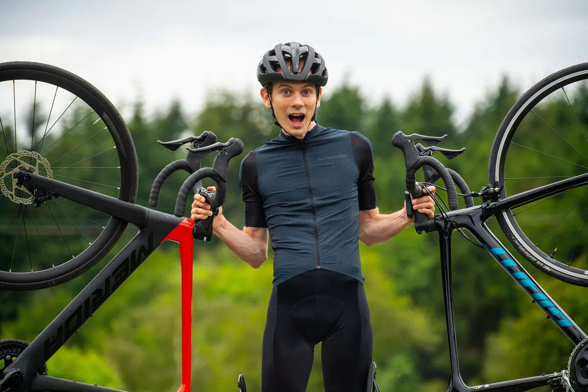 Matthew Loveridge doing a clickbait shocked face while holding up two modern road bikes